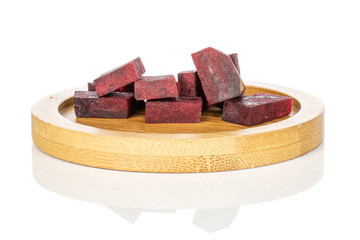 Lot of pieces of raw sweet beetroot on round bamboo coaster isolated on white background