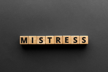 Mistress - words from wooden blocks with letters, mistress concept, top view gray background