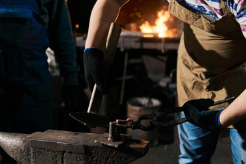 blacksmith forges a horseshoe, close-up