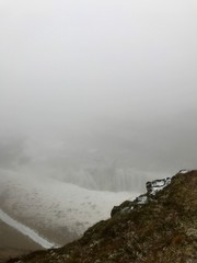 Breathtaking scenery at the Gullfoss Golden Waterfall landmark, a nature attraction in Iceland: Arctic nature with majestic rocks, the Hvita river running in the winter canyon with a cloudy white sky