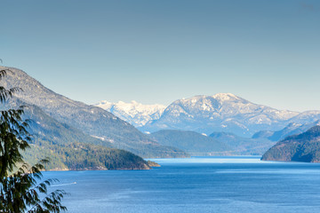 Fototapeta na wymiar Fantastic view over ocean, snow mountain and rocks at Sechelt inlet in Vancouver, Canada.