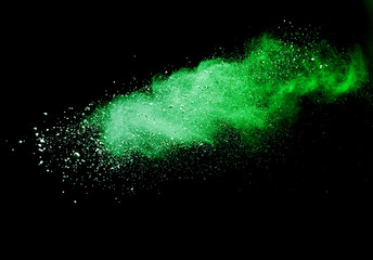 Green powder explosion on black background.