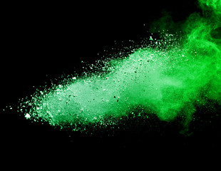 Green powder explosion on black background.
