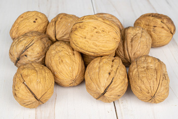 Lot of whole tasty brown walnut on white wood