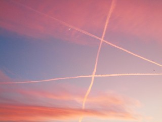 Genova, Italy - 01/25/2020: An amazing caption of the sunset in winter days over the city of Genova with beautiful red sky, some amazing clouds and small moonlight in the background.
