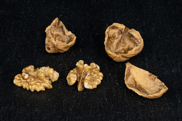 Group of two halves three pieces of tasty brown walnut on grey stone