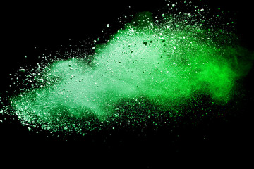 Green powder explosion on black background.