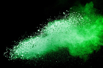 Green powder explosion on black background.