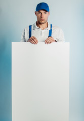 Mockup image of a young discoursged worker holding empty white banner. White or blue background....