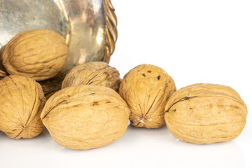 Group of six whole tasty brown walnut in copper bowl isolated on white background