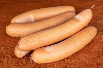Group of five whole pork frankfurt sausage on cognac leather