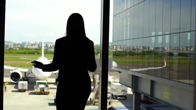 Pensive woman stay against terminal window of International airport. Business lady 