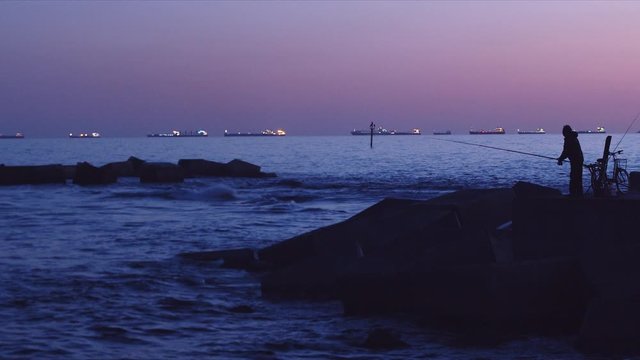 Pescador en el mediterr&aacute;neo, pescando en barcelona por la noche