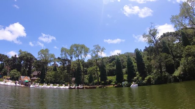 Hyperlapse of tourists at Lago Negro black lake park white swan and pirate ship pedal boat (pedalinho) - Gramado, Canela Rio Grande do Sul, Brazil