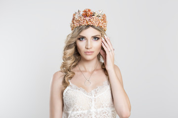 Beauty pageant queen. Serious woman in golden crown with pink coral brown stones gems crystals, white lace dress vogue style curly wavy hair curls looking at you camera isolated white grey background