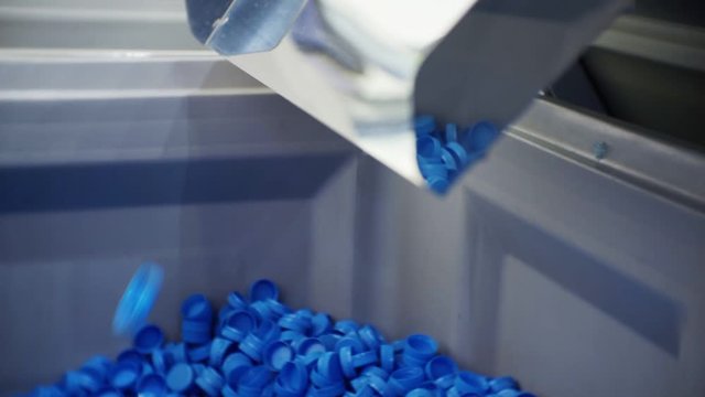 modern production.plastic processing and production.round blue plastic bottle caps moving along the production line.macro shooting.close-up.shallow depth of field.abstract technology background