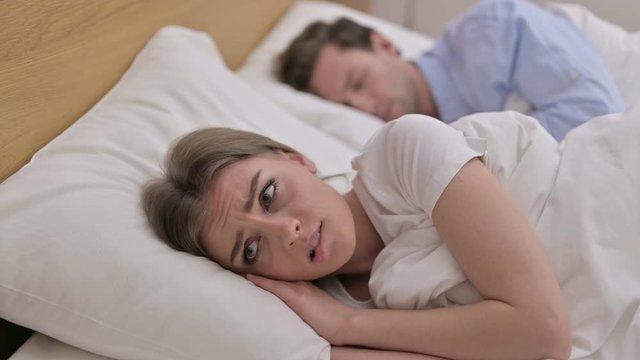Upset Young Woman Thinking about Family in Bed