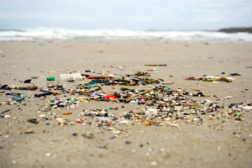 Low tide shows plastics and rubbish over the sand of a beach in As illas beach, Ribadeo, Lugo, Galicia, Spain