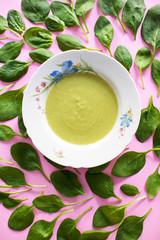 green soup in a plate on pink background. healthy diet concept 