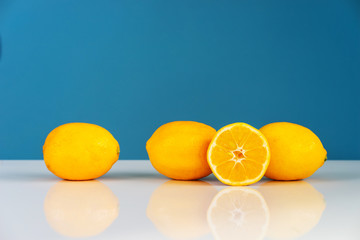 Yellow ripe lemon sliced in half juicy citrus fruit on the white table in front of the blue...