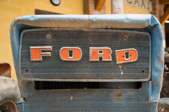 Vintage Ford logo sign on an old rusty tractor. Milan, October 01, 2017