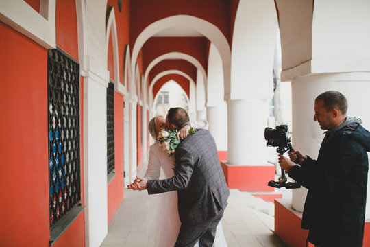 Wedding photographer taking pictures of the bride and groom in a gallery
