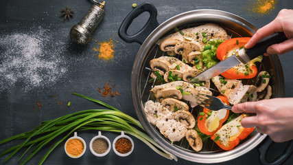 healthy food steamed chicken with mushrooms and vegetables on a black background