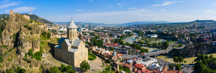 Panorama of the old town on Sololaki hill, crowned with Narikala fortress, the Kura river and cars traffic with blure in Tbilisi, Georgia.