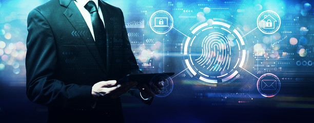 Fototapeta na wymiar Fingerprint scanning theme with businessman holding a tablet computer