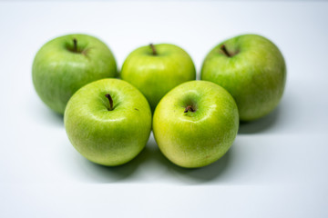 Five apples on white kitchen surface
