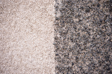 The texture of the wall is made of stone chips in two shades. division, halves.