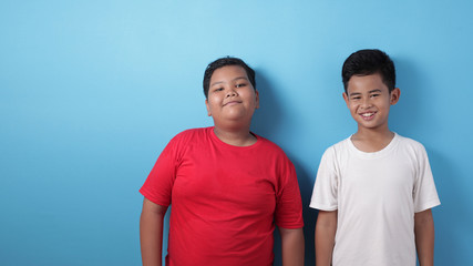Two Asian boys looking at camera, smiling and laughing, best friends happiness