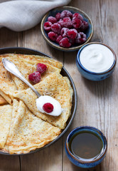 Pancakes served with sour cream, raspberries and honey. The traditional dish on Carnival and Maslenitsa.