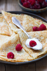 Pancakes served with sour cream, raspberries and honey. The traditional dish on Carnival and Maslenitsa.