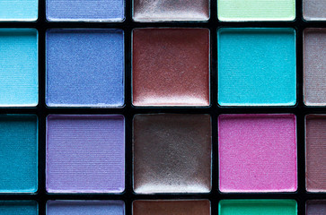 Multicolored professional make up eye shadow palette close up. Makeup concept background