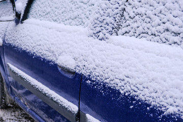 Snow covered car in an open parking