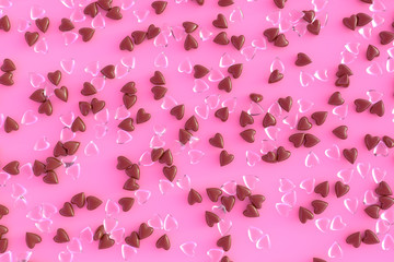 Lots of chocolate and glass of hearts scattered in a random order. Beautiful pink background with colorful hearts for Valentine's day