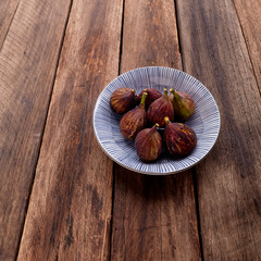 figs on plate on wooden table background