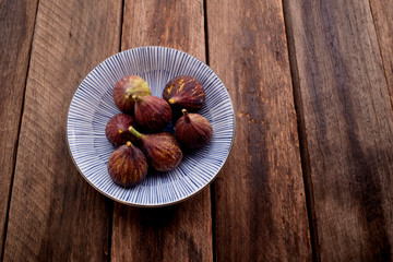 figs on plate on wooden table background