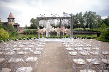 Beautiful blooming pink roses and baby's breath decorate the arch for the wedding ceremony. Luxury...