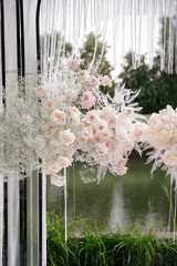 Beautiful blooming pink roses and baby's breath for the wedding ceremony. Luxury decorations for the arch. Holiday traditions.