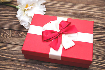 Real box with white and red bow and ribbon top view on Valentine's day isolated on wooden background. Flat lay. Copy space