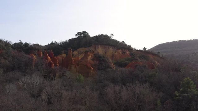 Red ochre mountain old quarry in an forest aerial shot Colorado Provencal Rustrel France