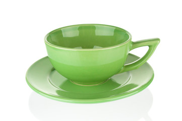 Empty green teacup with saucer on white background