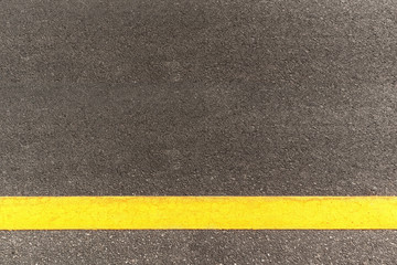 Black asphalt road texture with marking background. Horizontal yellow line on asphalt road.