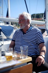 White bearded sailing senior, experienced skipper on a sailboat