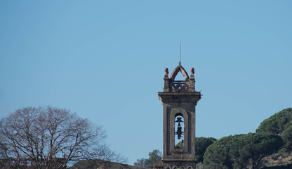 bell tower surrounded by trees and mountains