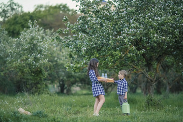 Children brother and older sister preparing for a picnic in the garden.