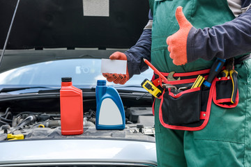 Car service advertising. Mechanic standing near car showing thumb up. Car with opened hood
