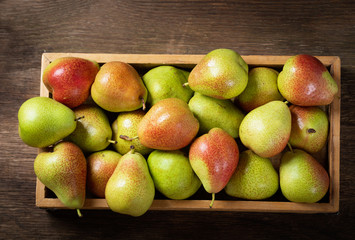 fresh pears in a wooden box, top view